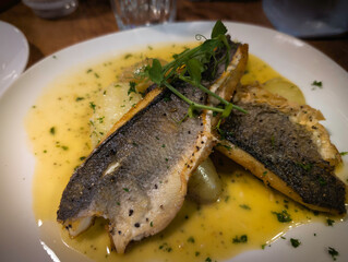Oven‑cooked sea bass served on a white plate, a delicious Italian dish highlighting Mediterranean flavor and culinary tradition.