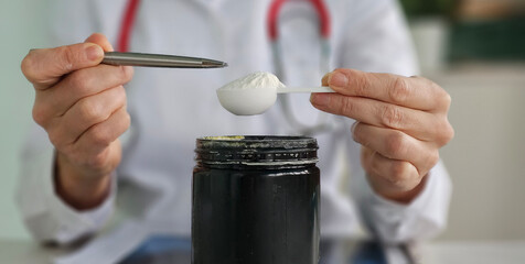 Healthcare professional prepares a supplement dose using a measuring spoon