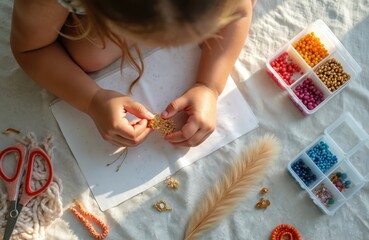 Top view of young girl hands carefully making beautiful handmade jewelry from many colorful beads on floor. Crafts unique diy bracelets, earrings at cozy home workshop. Creative hobby develops kids