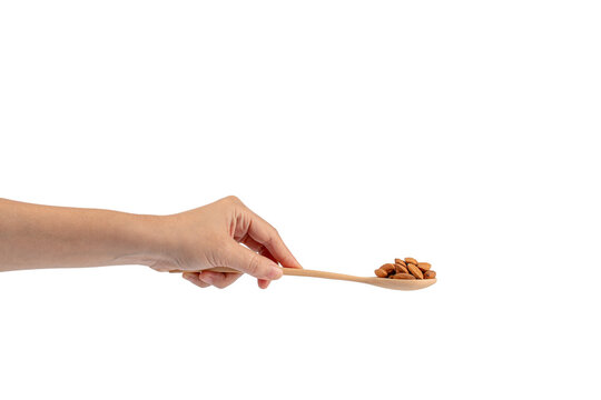 Wooden spoon with almonds in hand on transparent background