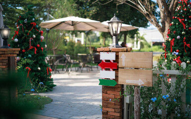 close-up view, wooden sign with colorful sign hanging on fence with christmas tree and item to decorate on background, celebrate in christmas holiday