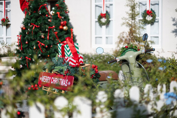 close-up, gifts with bow tie on motocycle rear of the motocycle have red sign with merry christmas text, and decorate of christmas event background