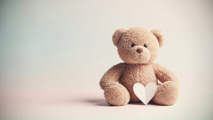 Obraz premium A soft, fluffy brown teddy bear sits on a pastel background, gently holding a white paper heart. The image conveys warmth, love, and comfort, perfect for Valentine's Day or sweet gestures.