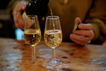 Person pouring effervescent sparkling wine into a glass