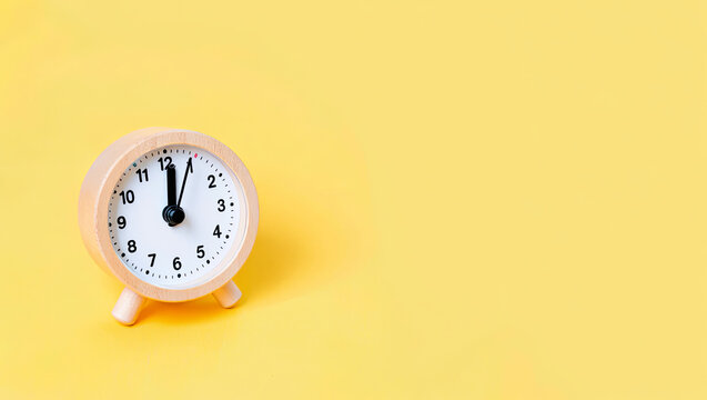 Clock on a yellow background marking the passage of time and creating a cheerful atmosphere for any setting
