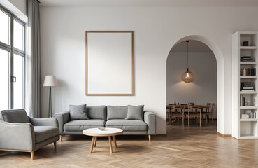 Fototapeta premium Modern living room with gray sofa and armchair. Empty frame above couch. Archway to dining area with table and chairs. Bookshelf with decor. Bright natural light from large window.