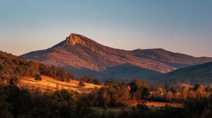 Experience the beauty of Pilot Mountain at sunrise with autumn colors glowing on the landscape perfect for travel inspiration and showcasing scenic destinations in your designs