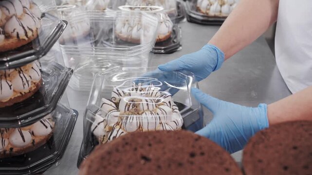 Baker Packing Meringue-Topped Cake Into Clear Takeout Container. Bakery and Confectionery Production