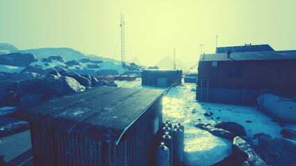 A tranquil arctic village lies nestled among icy formations, with rugged rocks and frosty structures under a soft, ethereal glow.