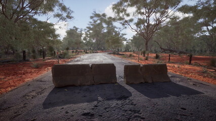 Two large stones obstruct the unpaved road, surrounded by vibrantly colored earth and lush eucalyptus trees under a clear blue sky, capturing a moment of stillness in nature.