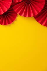 Lunar New Year 2026 concept. Flat lay Chinese red paper fans on yellow table.