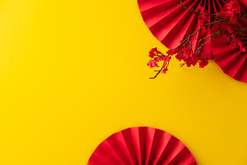 Happy Chinese New Year 2026 year of the horse concept. Oriental Asian style paper fans and cherry blossom branch on yellow table.
