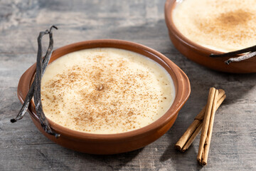 Creamy homemade Spanish custard served in a bowl with cinnamon on wooden table