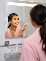 Woman Skincare Routine in Bathroom Mirror