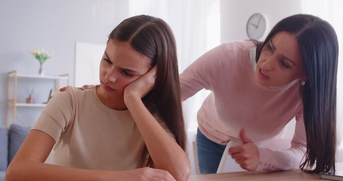 Worried mother trying to comfort her depressed sad adolescent daughter who has some problems, helping in difficult life situation, solving psychological problem. Misunderstanding in family