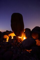 Balancing rock formation at twilight under a starry sky with golden light