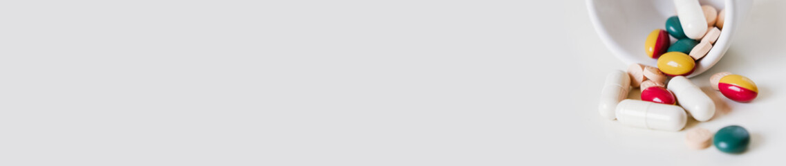 Ultra wide banner with tablets, panorama image for website of doctor's medicinal practice, pharmacy or supplements online shop, banner with pills, capsules and medication on white background