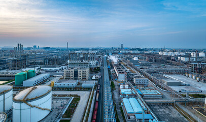 Aerial panoramic view of a massive industrial district with factories and storage tanks.