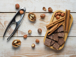 walnuts and hazelnuts, cinnamon, chocolate with nuts, nutcracker, background, Christmas wallpaper on a wooden countertop