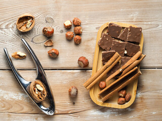 walnuts and hazelnuts, cinnamon, chocolate with nuts, nutcracker, background, Christmas wallpaper on a wooden countertop