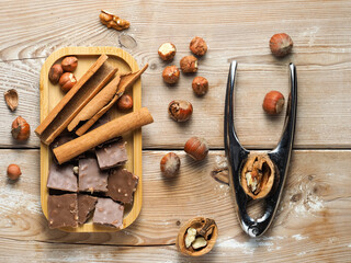 walnuts and hazelnuts, cinnamon, chocolate with nuts, nutcracker, background, Christmas wallpaper on a wooden countertop