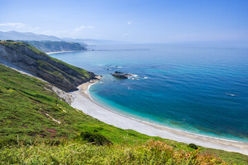 Asturias coastline with beach, green cliffs and clear blue sea