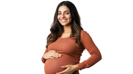 Expecting mother poses happily while showing off her baby bump in cozy sweater during bright indoor setting.