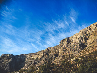 Fototapeta premium Steep Rocky Cliff Face Under Bright Blue Sky in Cape Town