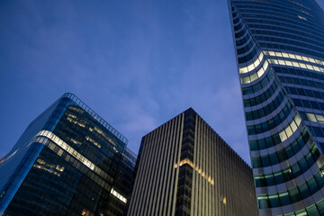 Urban architecture expressed through glass geometry and reflection accents in a low-angle corporate scene emphasizing skyscraper finance aesthetics within La Defense Paris