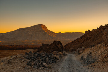 Road among mountains at sunset. Lunar landscapes at golden hour in Teide National Park, Tenerife,...