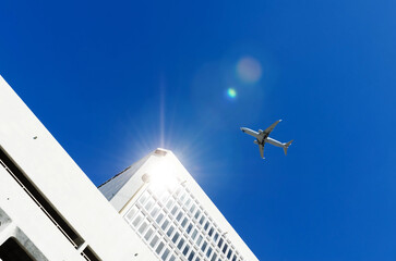 sunlight reflected on office building and airplanes on blue sky