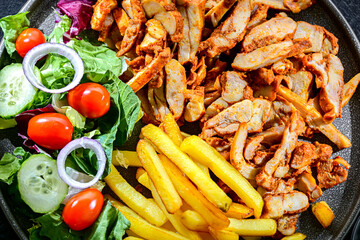 Kebab served with french fries and vegetables