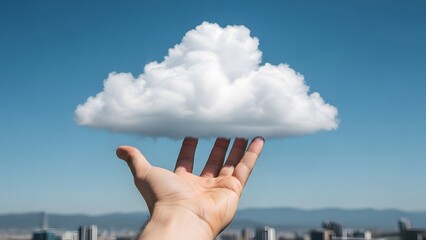 Hand holding a cloud against a blue sky