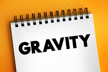 Gravity is a fundamental interaction which causes mutual attraction between all things with mass or energy, text concept on notepad
