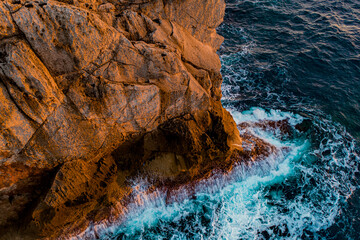 Naklejka premium Waves crash against the rocks on the Mediterranean coast Mediterraneo Islas Baleares