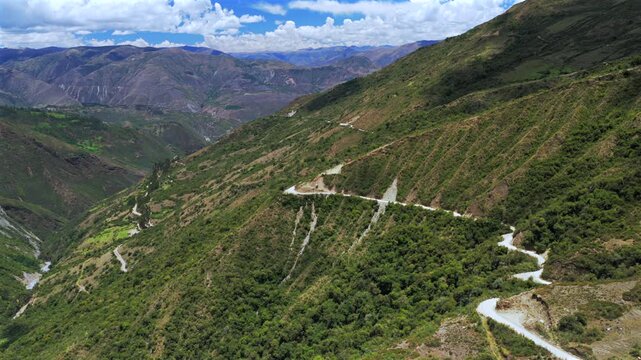 Car driving windy dirt road dust Soray Laguna Lake Humantay Sulcantay Trek Peru Per&uacute; aerial drone clouds blue skies high altitude elevation Peruvian Andes Mountain Range peaks forward follow motion