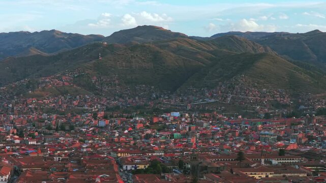 Cusco Cuzco Per&uacute; cityscape aerial drone Vive en el Peru mountain hillside high altitude colorful Inca neighborhood buildings main square Plaza De Armas sunset golden hour blue skies clouds upwards pan