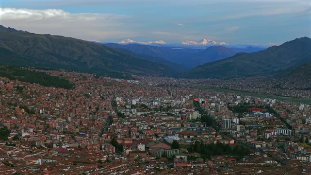 Cusco Cuzco Peru Per&uacute; cityscape international airport aerial drone high altitude snow capped Peruvian Andes colorful Inca neighborhood buildings sunset golden hour blue skies clouds backwards