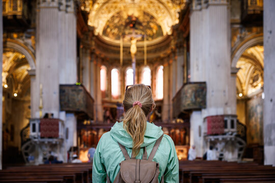Woman visitor admiring church interiors and traditional italian christian architecture while sightseeing in Italy