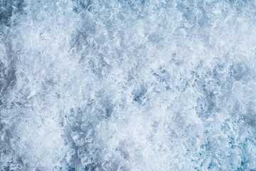 Close up texture fluffy white snow creating soft wintry surface. For Christmas backgrounds, seasonal designs and festive holiday projects.