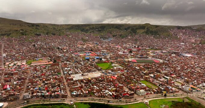 Populous and densely built Puno city on lakeshore of Lake Titicaca, Peru. Aerial