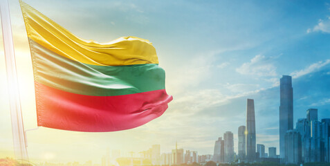 Lithuania  flag wavering in beautiful clouds with building skyline. The flag with drone shot in...