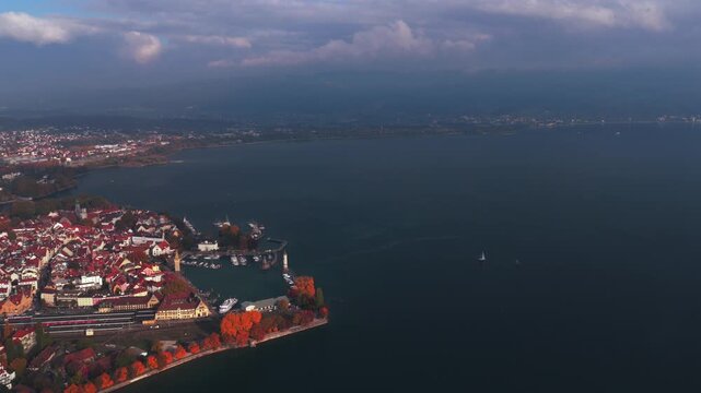 Obersee Bodensee Landau Germany Switzerland aerial drone harbor view island fall autumn leaf golden hour sunset clouds shoreline marina sailboat ferries train European lake Constance circle left