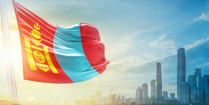 Mongolia flag wavering in beautiful clouds with building skyline. The flag with drone shot in beautiful sky. Mongolia national day flag for independence day. - Powered by Adobe