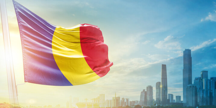 Romania flag wavering in beautiful clouds with building skyline. The flag with drone shot in beautiful sky. Romania national day flag for independence day.