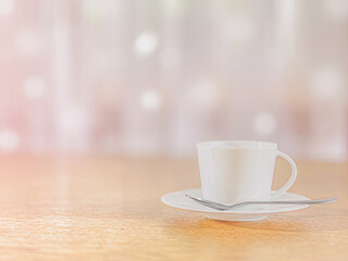 Mixed background. A white coffee cup on a saucer with a spoon rests on a wooden table.