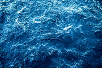 Fototapeta premium Sunlight reflects off the ocean surface, creating a vibrant display of deep blue waves rolling gently throughout the water