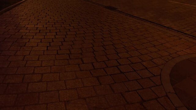 Close up of ancient cobblestone pavement in warm sunset light, historic European street texture, golden hour urban background.