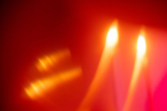 soft glow of flickering candle flames against a vibrant red background creating an abstract visual effect, neutral background, clear negative space, clean composition, balanced framing, minimalist