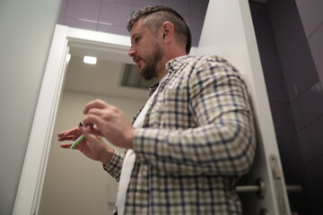 Man preparing to shave with disposable razor in bathroom